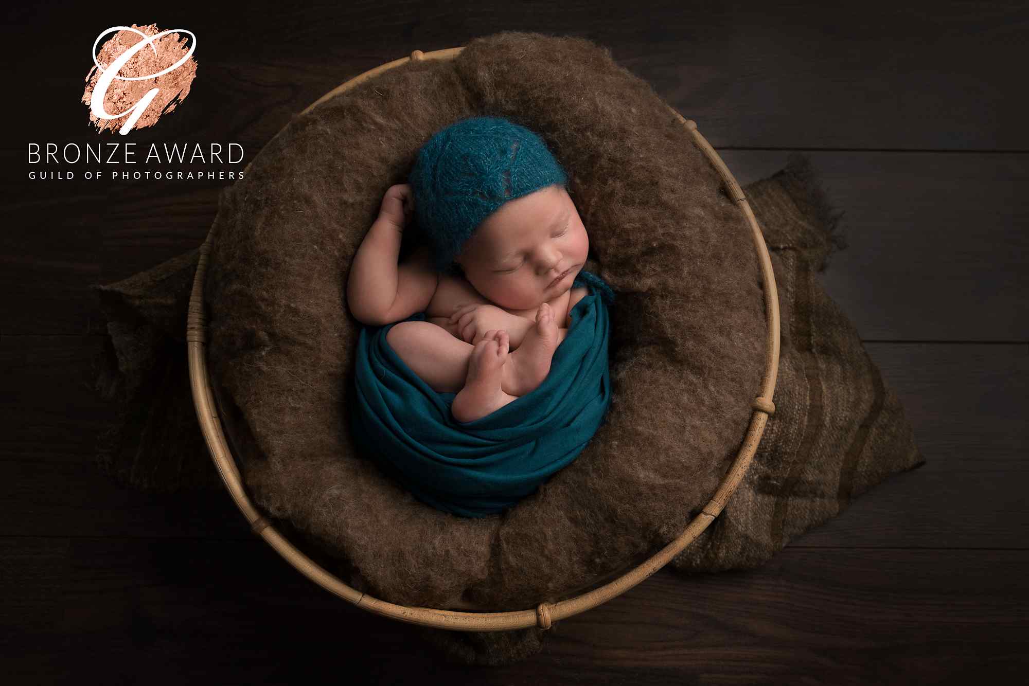 little newborn baby boy in a brown basket