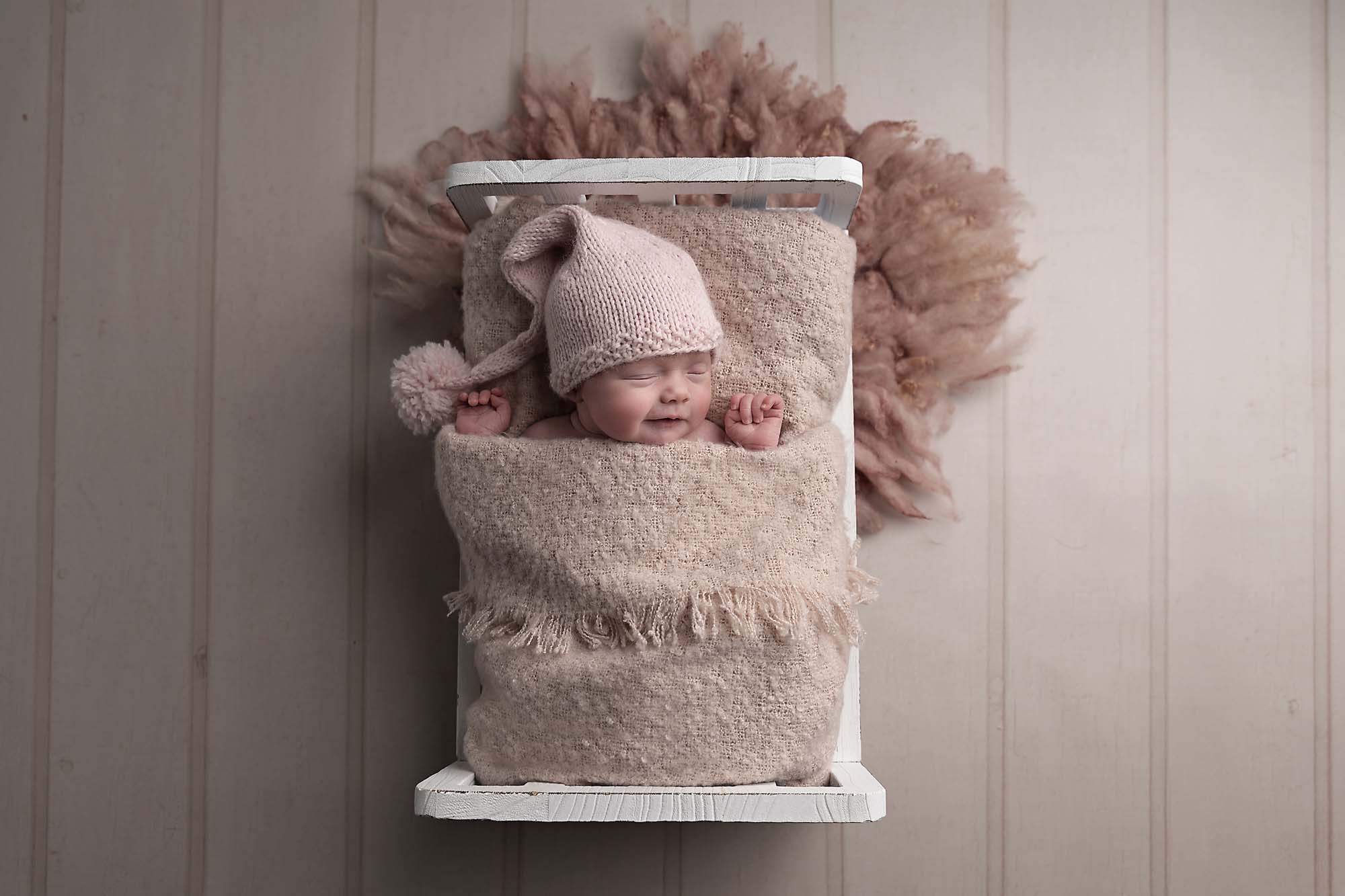 newborn girl in pink blanket on bed photographed by Newborn Photographer Cheshire