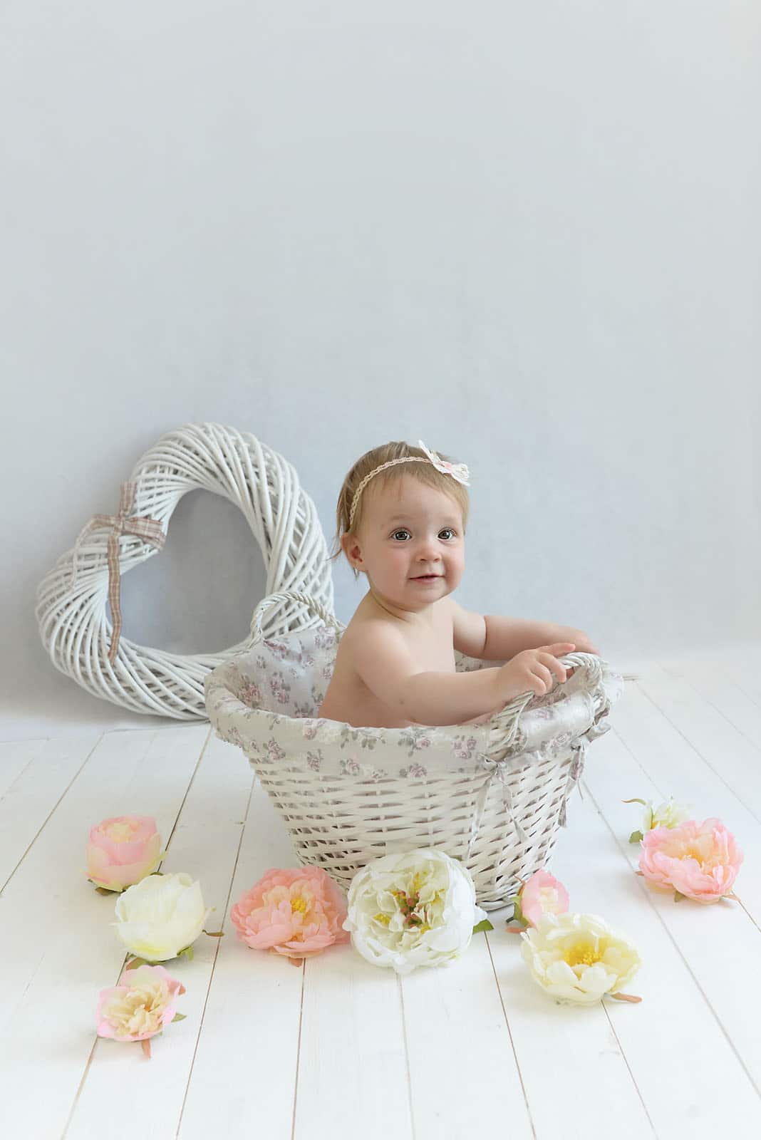 baby girl sitting in a basket photographed by Baby Photographer Manchester