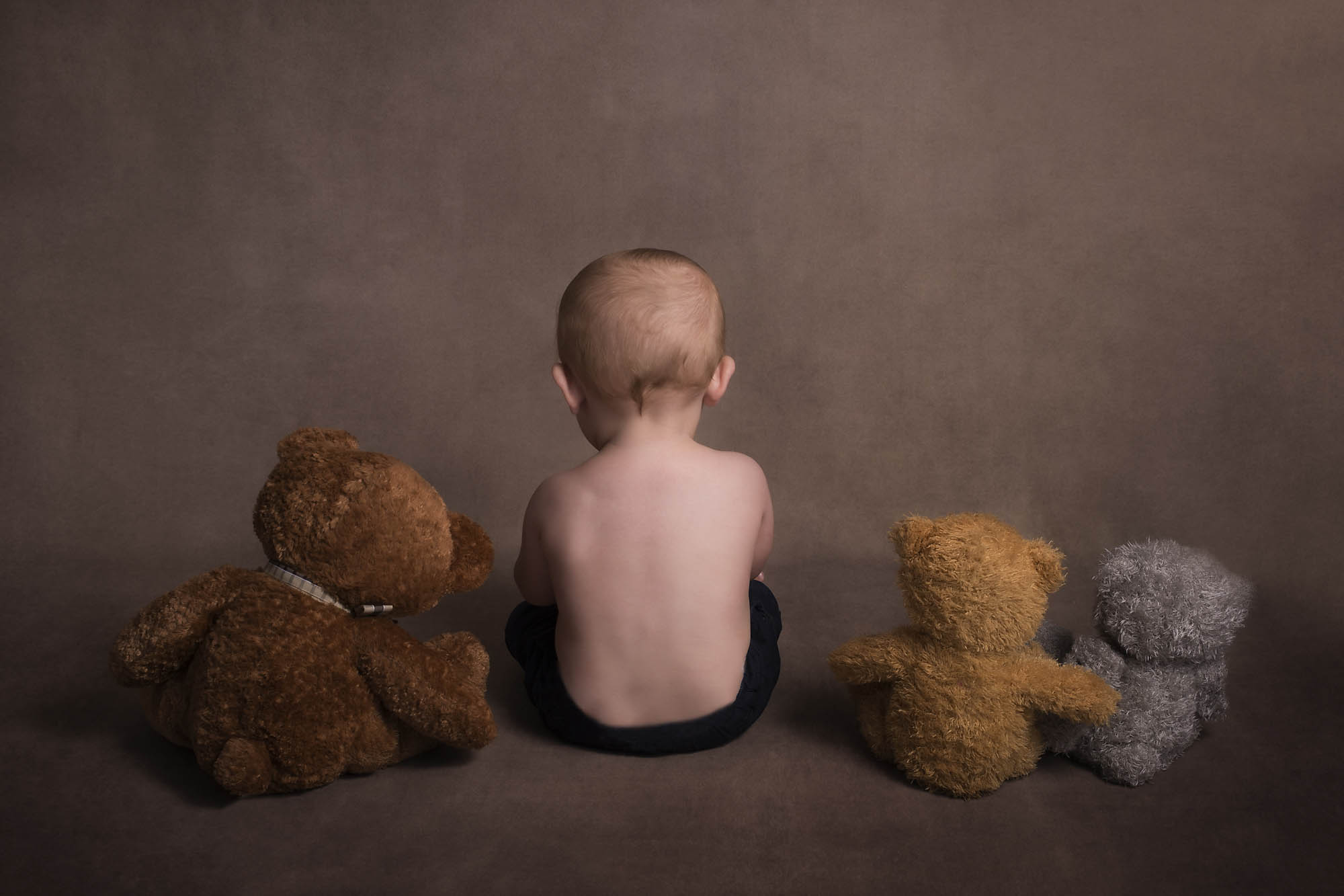 baby boy is sitting with teddies photographed by Baby Photographer Manchester