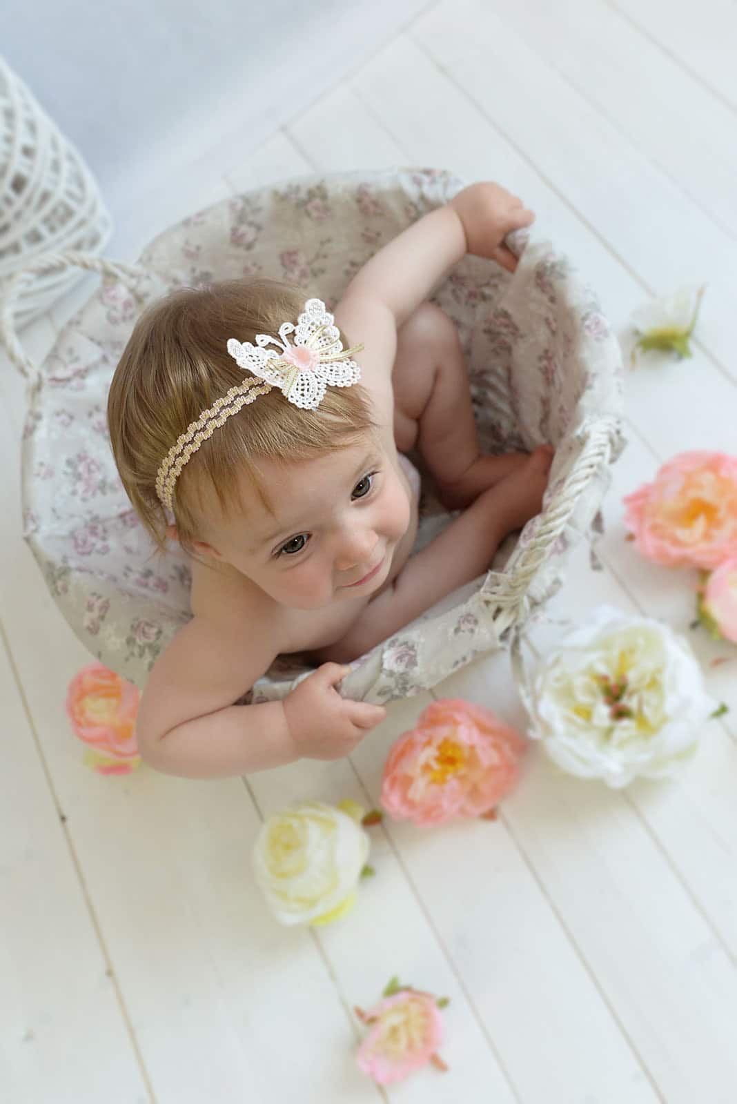 toddler little girls is sitting with flowers photographed by Baby Photographer Manchester