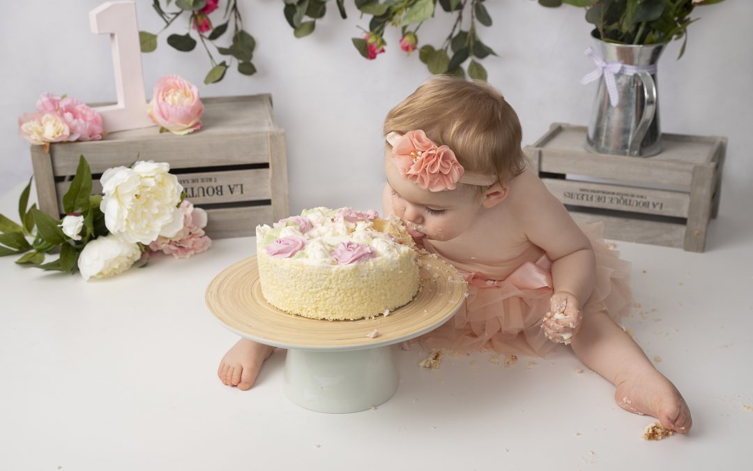 One year old little girl eating a cake photographed by cake smash photography Manchester