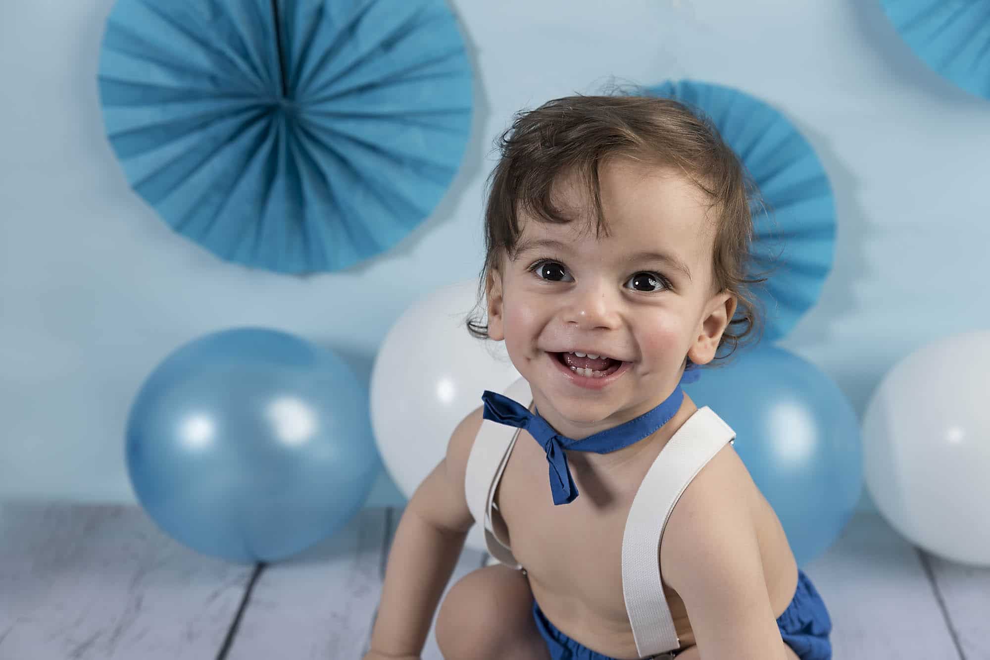 one year photoshoot with a boy and blue baloons photographed by cake smash photography Manchester