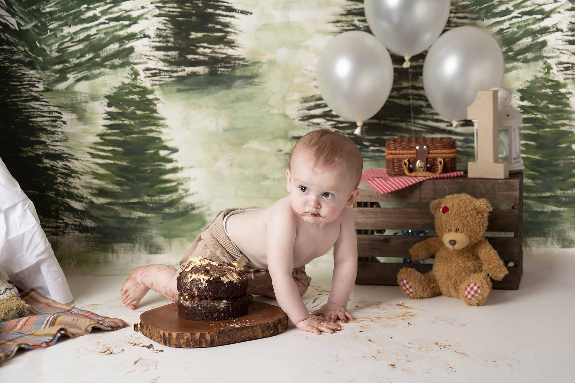 cakesmash with little boy in the forest background photographed by cake smash photography Manchester