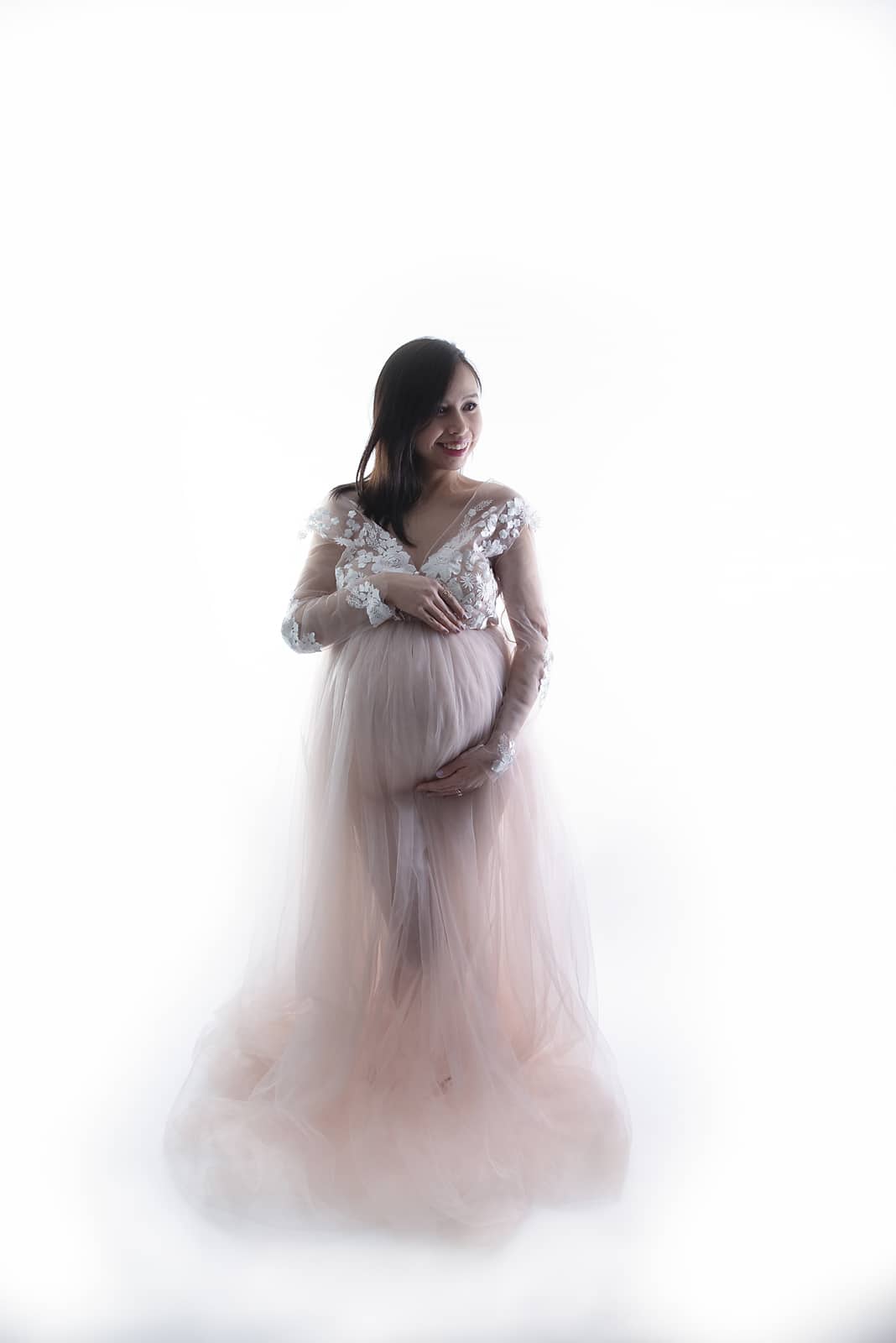 pregnancy photoshoot in a studio with white lace dress and white background photographed by Maternity Photographer Manchester