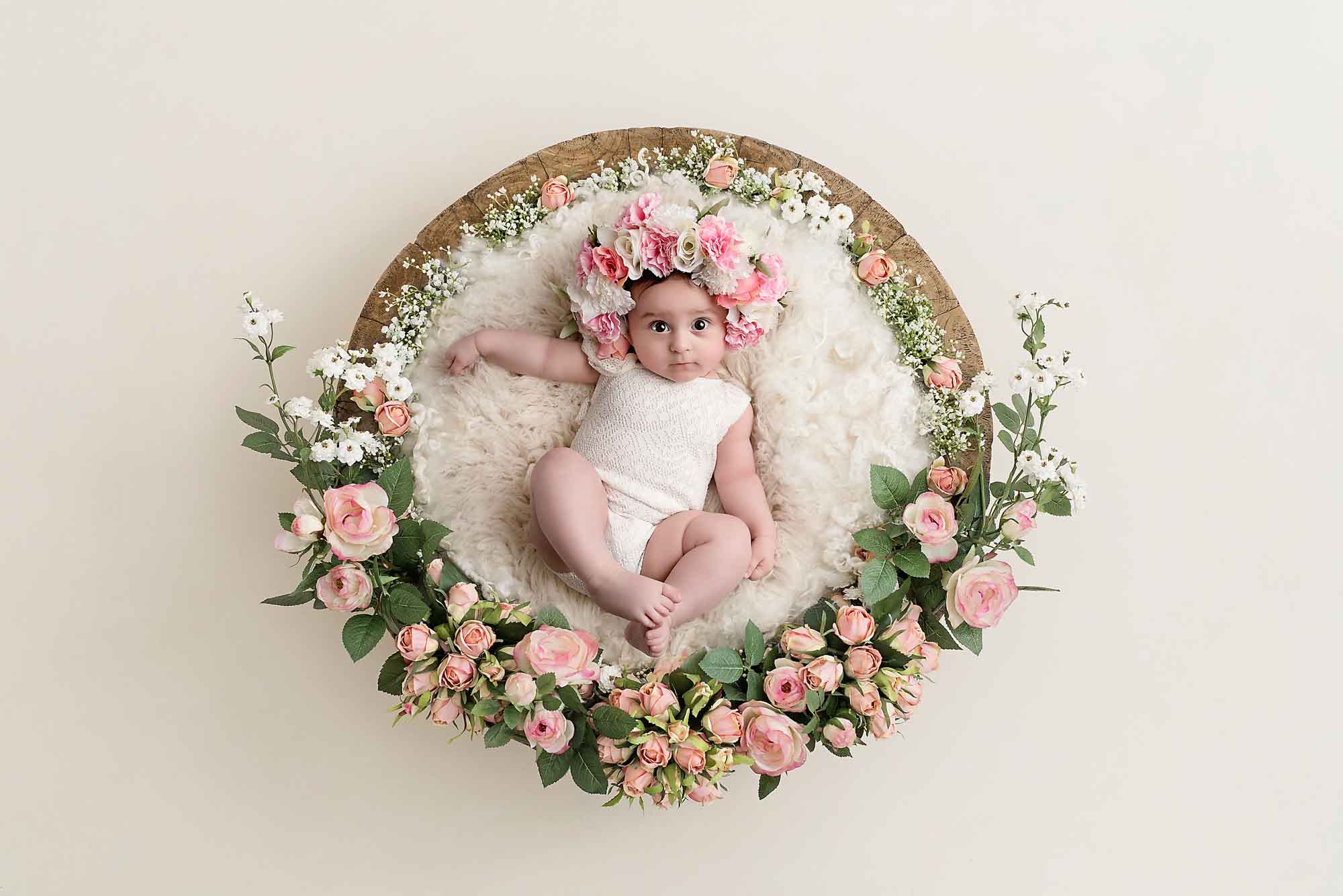 baby girl in a basket with flower bonnet by baby photography Manchester