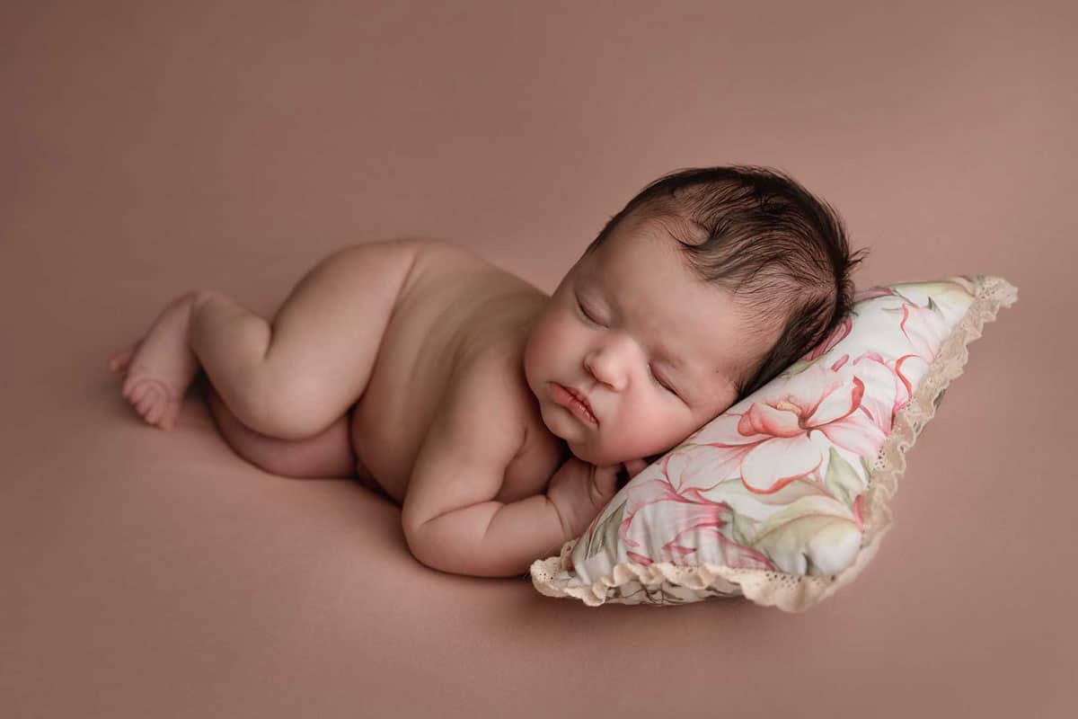 newborn baby girl is sleeping on the pilow taken by newborn photography manchester
