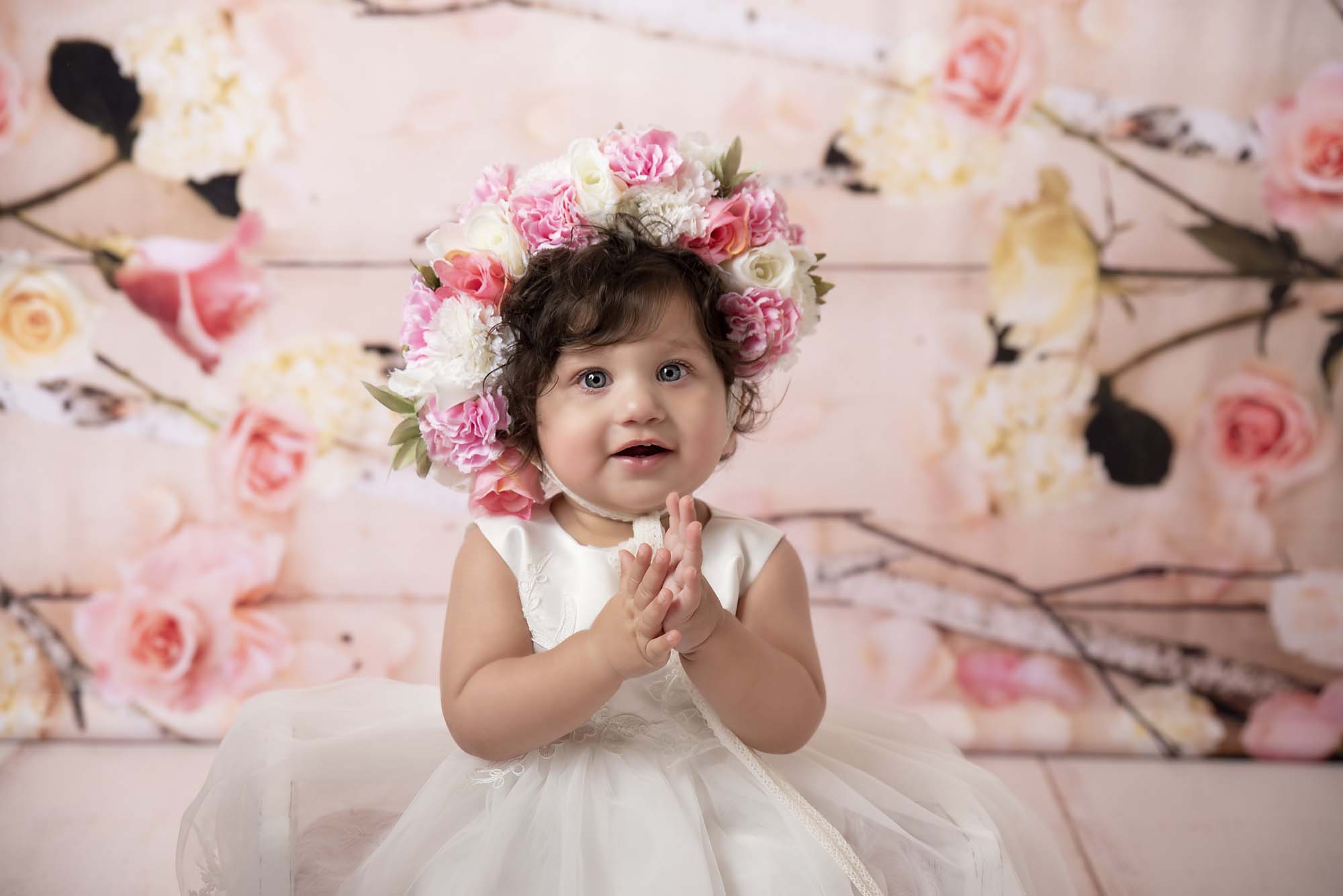 sitter little girl with flower headband by cake smash photography Manchester