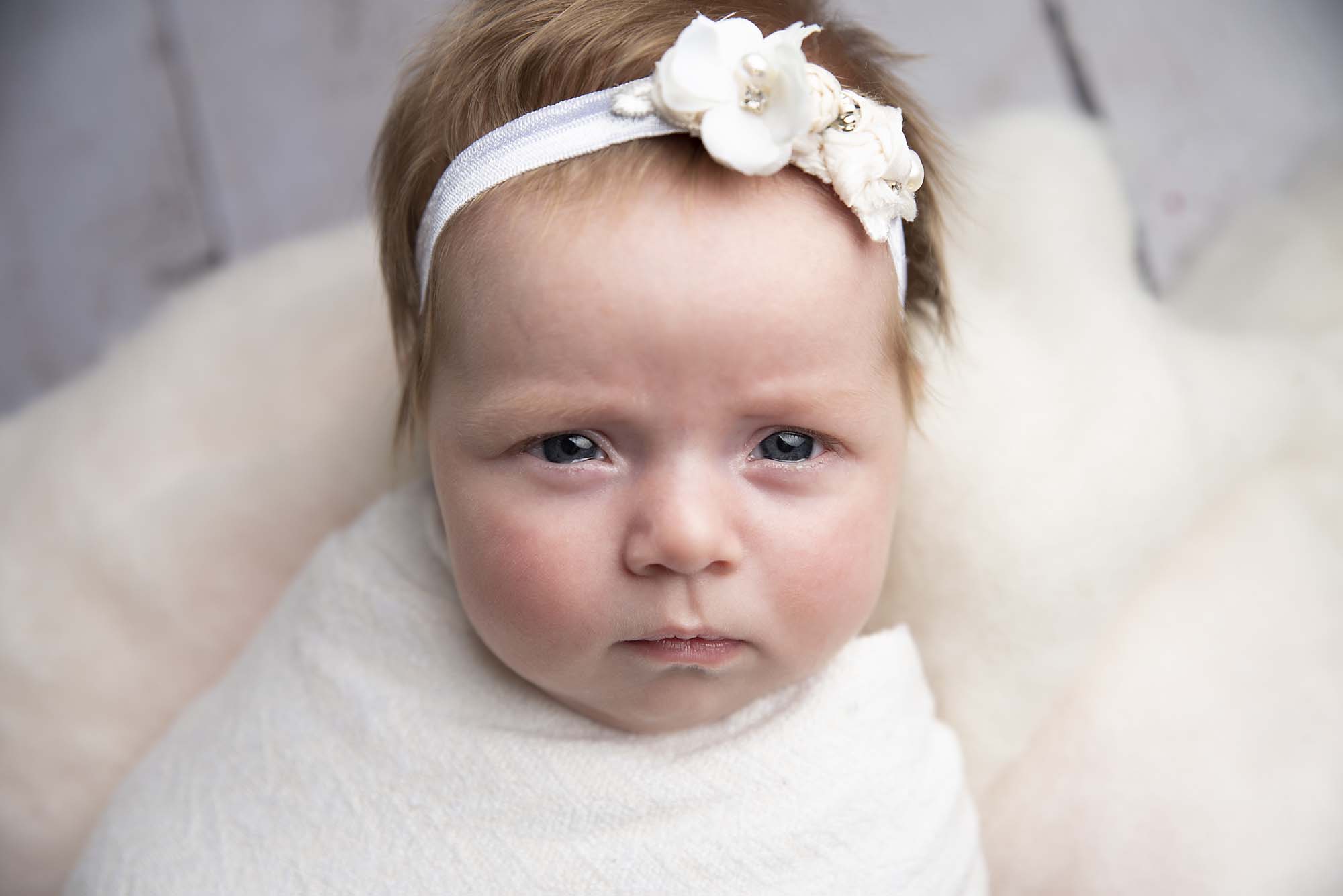 newborn baby girl with white headband taken by newborn photography manchester