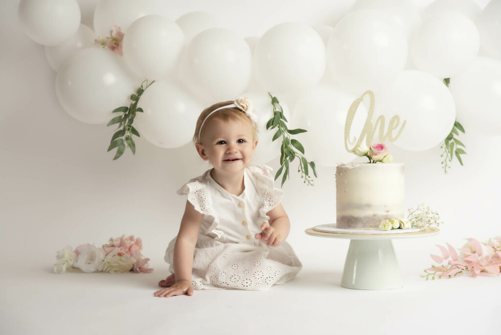 cakesmash with white balloons and white cake