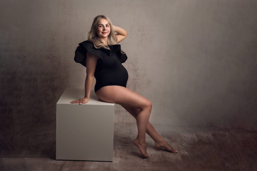 maternity photography taken in Manchester pregnancy studio with black body sitting on a cube