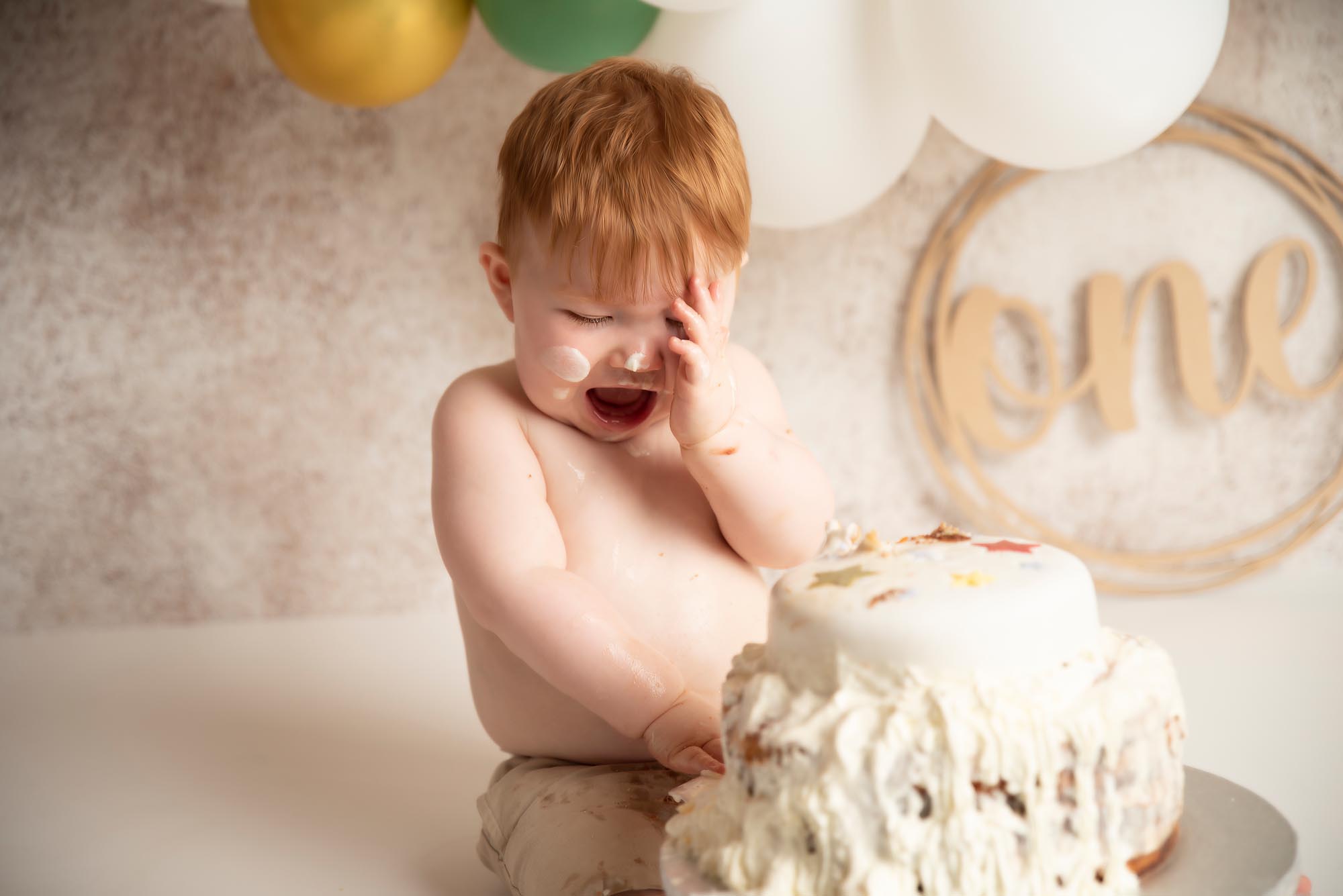 happy one year old baby with his cake