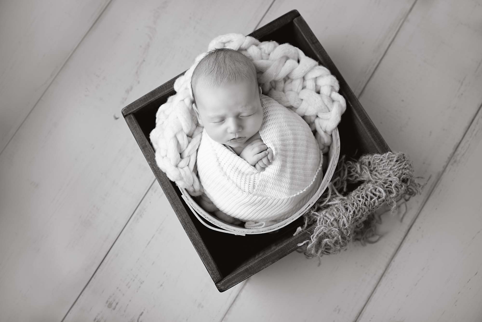 black and white newborn photography baby in basket monochrome image