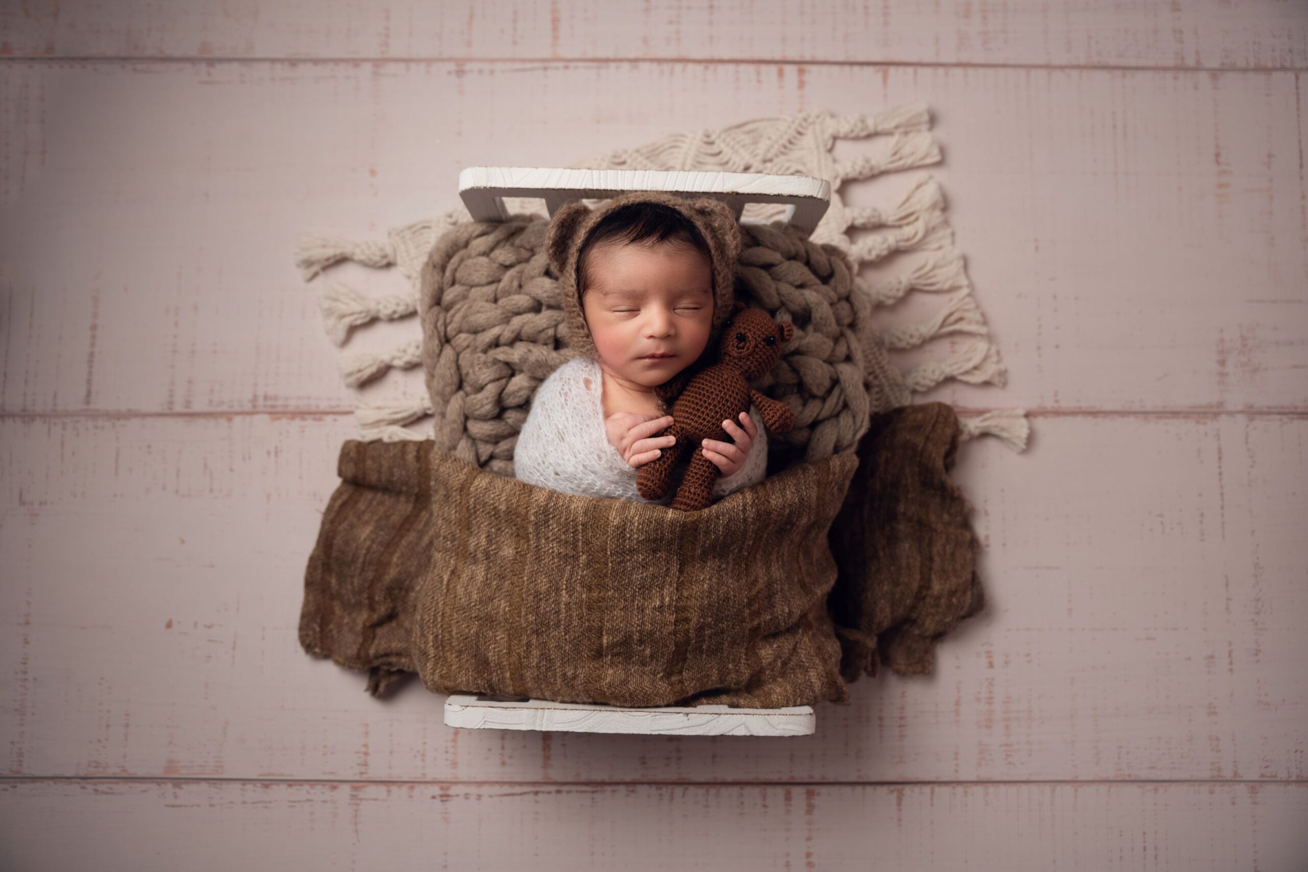 Photoshoot booking Newborn baby wrapped in cream blanket during a photoshoot at Dora Horvath Photography studio in Manchester